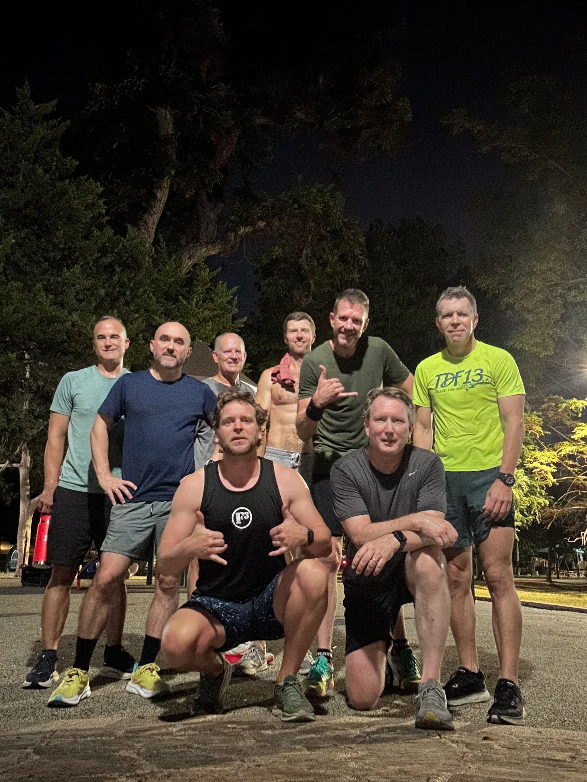 F3 Dallas members standing and kneeling together at a park at night